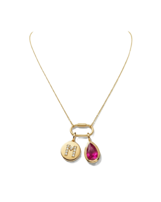 Gold necklace with a teardrop-shaped pink gemstone pendant and a round pendant with a letter 'M'.