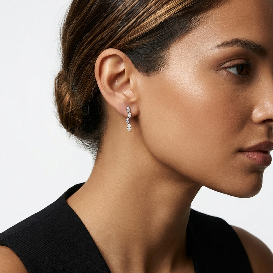 Close-up of a woman wearing diamond earrings with a neutral background
